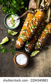 Serving Grilled Corn Cob With Fresh Herbs,lime,beer At Picnic, Top Down Table View.