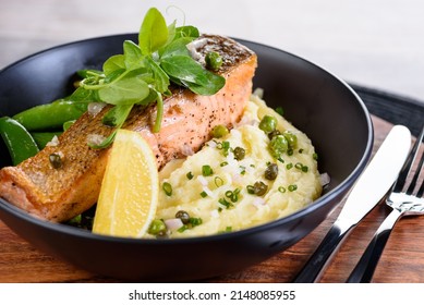 A serving of grilled salmon on a bed of mash potato, green beans and a wedge of lemon - Powered by Shutterstock