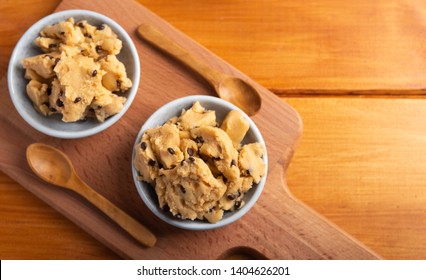 A Serving Of Homemade Cookie Dough On A Wooden Table, With A Wooden Spoon. Top View.