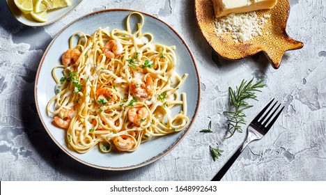 Serving Of Italian Noodles With Fresh Scampi Garnished With Herbs And Grated Parmesan Cheese Viewed From Overhead In A Flat Lay Still Life
