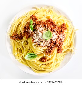 Serving Of Italian Spaghetti Bolognese With Ground Beef, Parmesan Cheese And Fresh Basil Leaves For A Tasty Traditional Mediterranean Cuisine, Overhead View On White