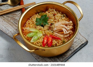 Serving A Korean Style Instant Noodle, Ramyeon Or Ramyun With Spicy Flavour Topped With Egg Yolk, Chilli, Vegetables And Kimchi In A Traditional Korean Noodle Pot.