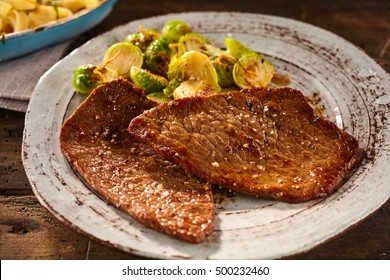 Serving Of Marinated And Cooked Minute Steak With Sliced Brussels Sprouts In Round Ceramic Blood