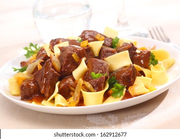 Serving On A Plate Of Beef Goulash, A Stew That Originated In Hungary, Served With Noodles And Garnished With Fresh Chopped Parsley