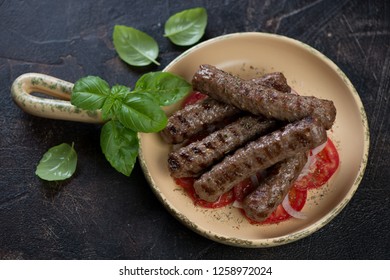 Serving Pan With Grilled Balkan Cevapi Or Skinless Beef Sausages, Studio Shot On A Dark Brown Stone Background