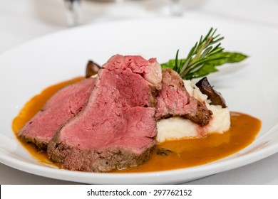 Serving of rare prime rib of beef with mashed potatoes and garnished with rosemary - Shutterstock ID 297762152