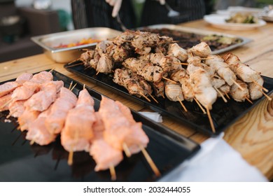 Serving Small Hot Chicken And Red Fish Kebabs On The Buffet. Catering For A Dinner Party On The Outdoors. Open Air Food Concept