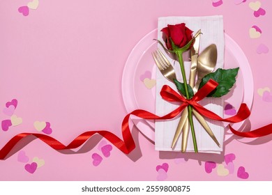 Serving table with golden fork, knife, spoon and red rose tied with red ribbon on pink dish. Valentine's Day or festive romantic dinner. - Powered by Shutterstock