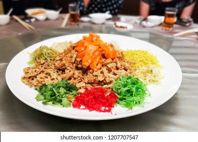 Serving of Yee Sang or Yusheng with raw salmon fish during Chinese New Year, for luck and prosperity