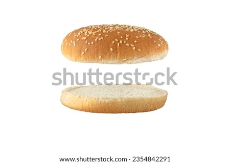 Sesame bun for burger top and bottom separated side view isolated on white. Round bread topped with sesame seeds cut in half.