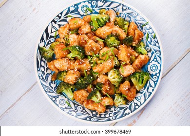 Sesame Chicken And Broccoli In Blue Plate. View From Above, Top Studio Shot