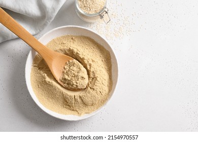 Sesame flour in bowl and sesame seeds in glass jar on white background. Top view. Copy space. Good source of protein, minerals, natural antioxidants and vitamins. - Shutterstock ID 2154970557