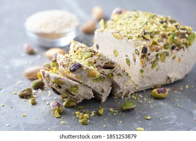 Sesame halva with pistachios on grey background. Top view. Copy space. Traditional middle eastern sweets. Jewish, turkish, arabic national dessert. Turkish delight.