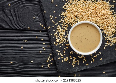 Sesame Tahini Paste On A Black Stone Background.