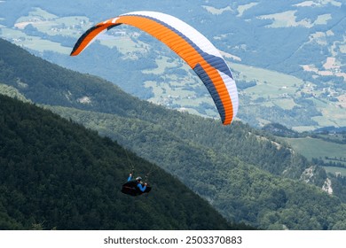 Sestola, Italy - 07 27 2024: Paraglider flies in the air. Aerial view of paragliding. Paraglider flies above the mountains in a bright sunny day. Concept of extreme sport.
 - Powered by Shutterstock