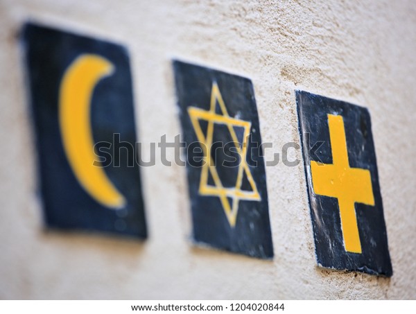 Set of 3 religious symbols: islamic crescent,\
jewish David\'s star, christian cross (wall sign on the street of\
Segovia, Spain)\
