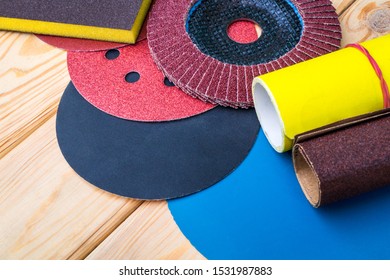 Set of abrasive tools different colors and sandpaper on wooden background. The wizard is used for grinding items