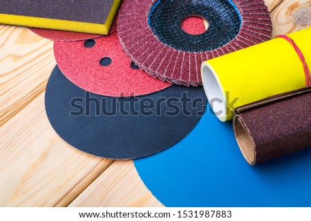 Set of abrasive tools different colors and sandpaper on wooden background. The wizard is used for grinding items