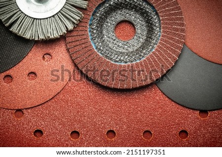 Set of abrasive tools and grinding discs on the background of sandpaper. Essential tools for master builder.