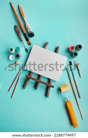 
set of accessories for painting with paints and brushes. fine art tools. creative composition in flatley style on a bright blue or turquoise background. top view. copy space.