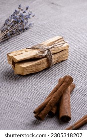 Set for aromatizing the room during meditation and yoga, air flavors in the dwelling: wooden sticks palo santo, lavender, cinnamon sticks close-up on the background of burlap - Shutterstock ID 2305318207