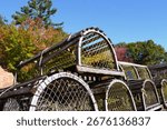 Set aside for storage, a large stack of weathered and faded vintage, wooden lobster traps sit in the sun in Maine.