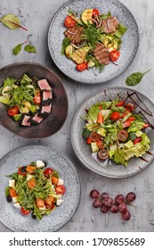 Set Of Assorted Delicious Salads Over Gray Concrete Background. Salad Bar. Overhead View, Flat Lay, Restaurant Menu