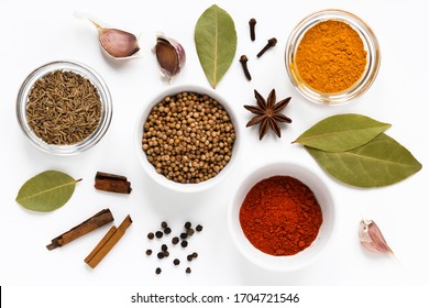 set of assorty colorful spices and herbs in bowls on white background, flat lay, top view