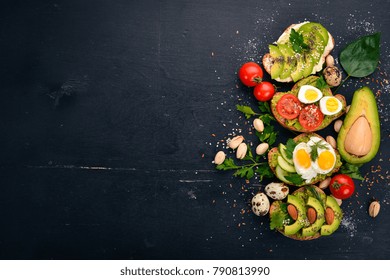 A set of avocado sandwiches, cherry tomatoes and quail eggs and chia seeds. On a wooden background. Top view. Free space for your text. - Powered by Shutterstock