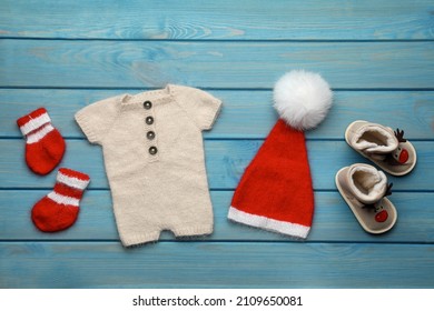 Set Of Baby Clothes For Christmas Photoshoot On Light Blue Wooden Background, Flat Lay