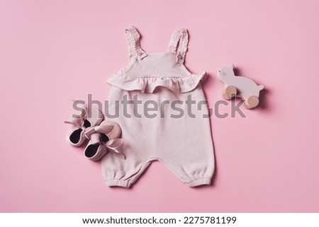 Set of baby girl clothes, shoes, accessories on pink background. Fashion newborn clothes. Flat lay, top view. Copy space.