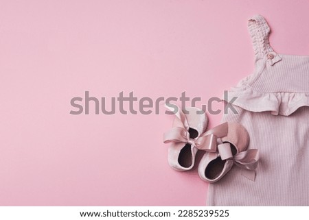 Set of baby girl clothes, shoes, accessories on pink background. Fashion newborn clothes. Flat lay, top view. Copy space.