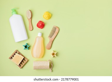 Set Of Baby Toiletries, Child Organic Hygiene And Bath Accessories, Shower Gel, Shampoo, Essential Oil, Towel On Green Pastel Background. Top View, Flatlay