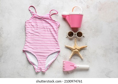 Set of beach accessories for children, stylish swimsuit and starfish on light background