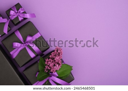 Set of black gift boxes with lilac flowers and violet ribbons. Horizontal, space for your text.