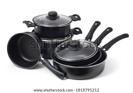 Set of black non-stick kitchen utensils on a white background. Pot, ladle, frying pan  with glass lid.