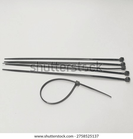 Set of black nylon cable ties or zip ties isolated on a white background for organizing wires
