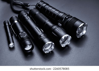 Set of black pocket tactical flashlights isolated on black background