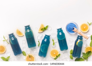 Set of blue detox bottles with fresh lemon slices inside on white background, copy space - Shutterstock ID 1496030444