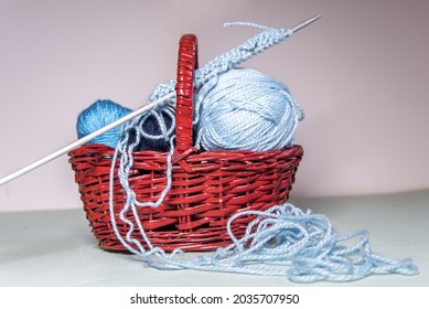 A Set Of Blue Wool Thread Balls Of Different Sizes Inside A Wicker Basket. Knitting Needles And Messy Thread. At Home Hobby. Crocheting. Balls Of Yarn.