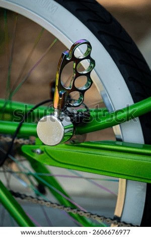 A set of brass knuckles attached to part of a bright green 