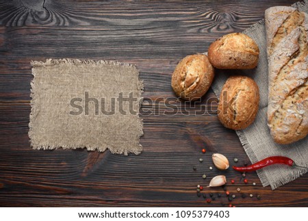 A set of bread, pepper, garlic on a brown wooden board. Top view with space for your text.