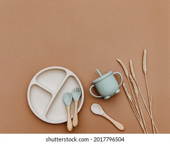 Set with bright baby dishware on table, silicone set on a trendy brown background, flat lay. Serving baby food. - Shutterstock ID 2017796504