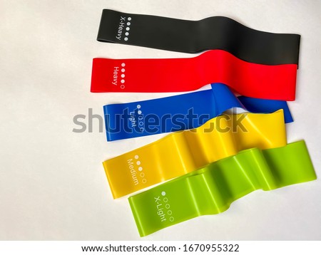 Set of bright multi-colored latex rubber bands for fitness on a white background.  sports concept.  fitness trend.  top view, flat lay, copy space.