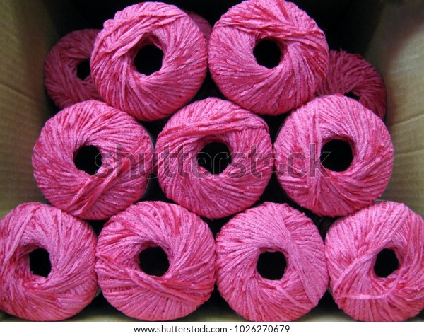Set of bright pink rayon chenille yarn balls in a\
carton box