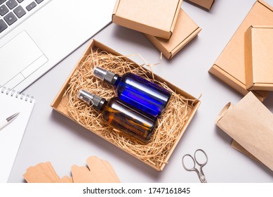 Set Of Brown And Blue Glass Spray Bottles Packed In Cardboard Box On Office Desk