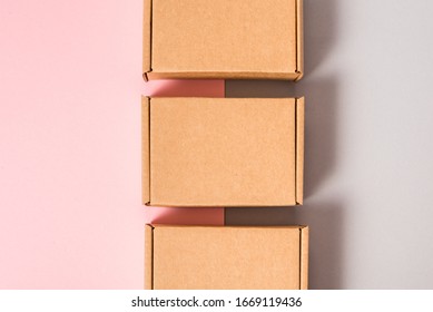 Set of brown cardboard boxes on pink and grey background
