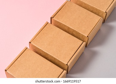 Set of brown cardboard boxes on pink and grey background