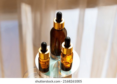 Set of brown glass dropper bottles with a pipette on a metal and glass background. Organic, natural cosmetics. Beauty, skin care. Spa products. Close up, copy space. Selective focus