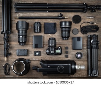 Set Of The Camera And Photography Equipment (lens, Tripod, Filter, Flash, Memory Card, Hard Desk, Reflector) On Wood Desk. Professional Photographer Accessories Background.